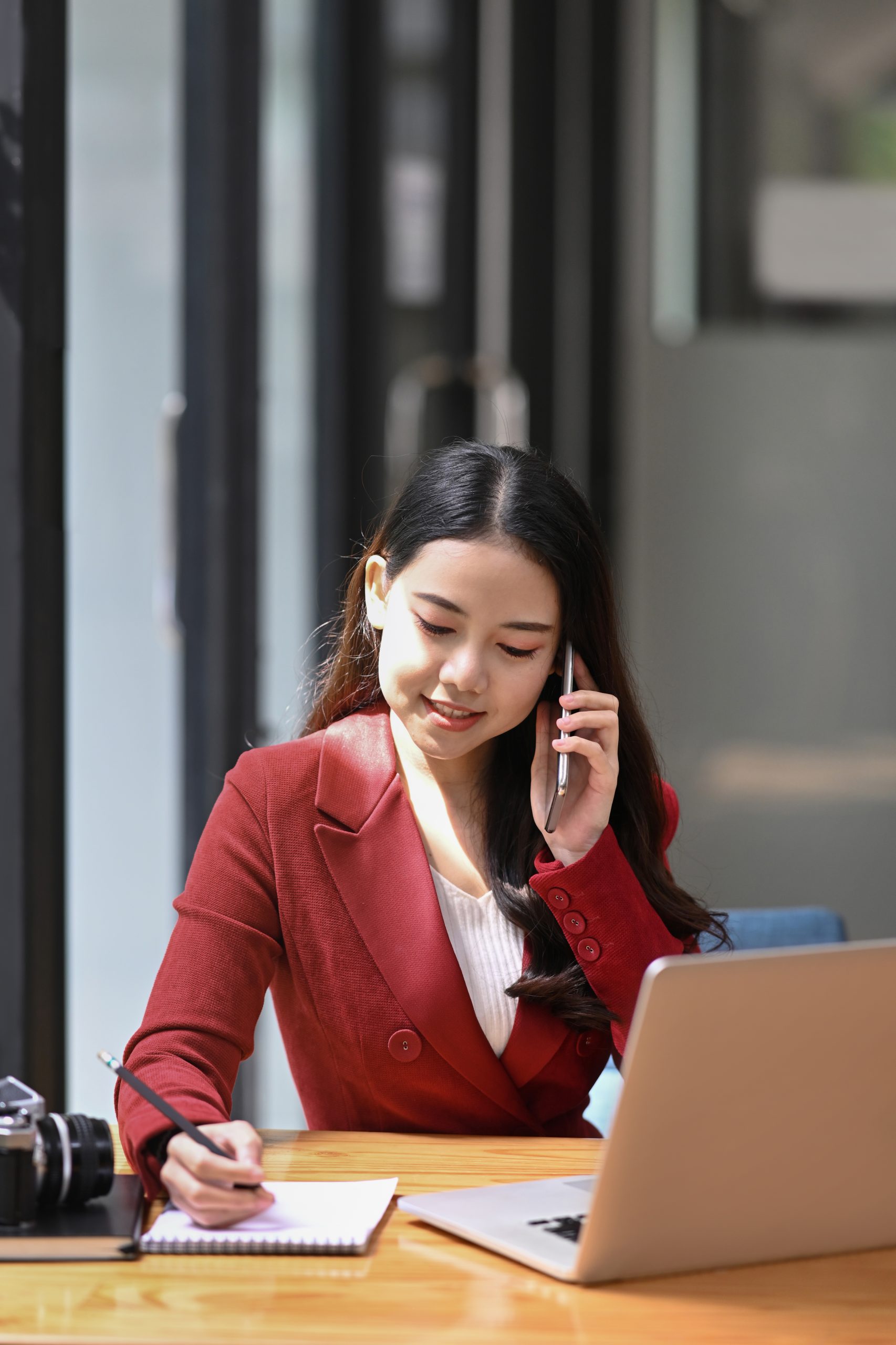Attractive businesswoman sitting at her workplace and talking on